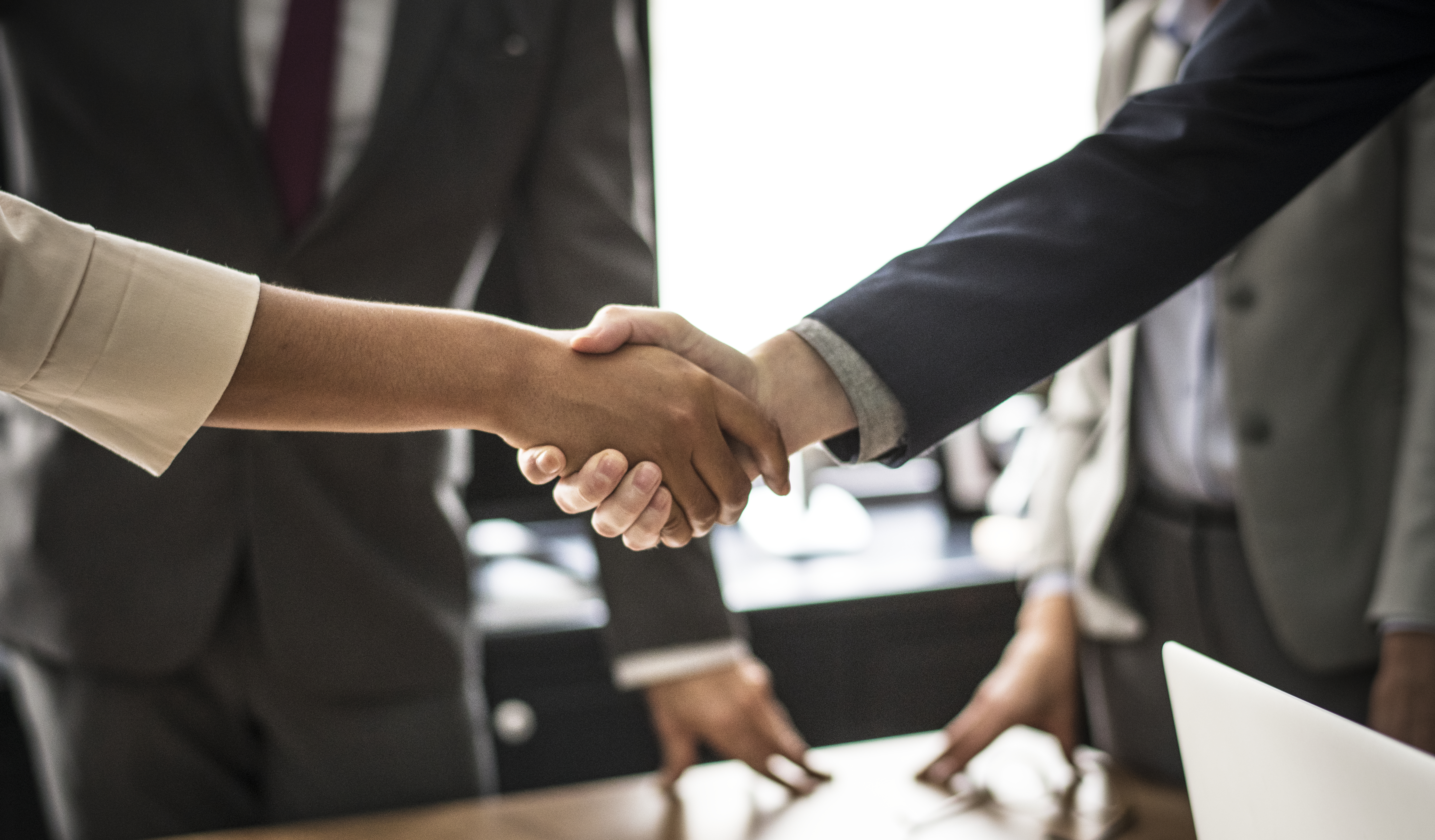 business-people-shaking-hands-meeting-room (1)